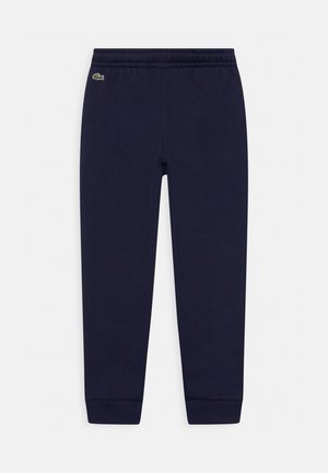 Pantalones jogger azul marino con cintura y puños elásticos, con un pequeño logo de cocodrilo verde cerca de la cadera izquierda.