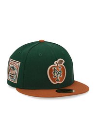 Green fabric baseball cap with a brown brim. Features an embroidered orange apple logo and a patch on the side celebrating the Mets' anniversary.