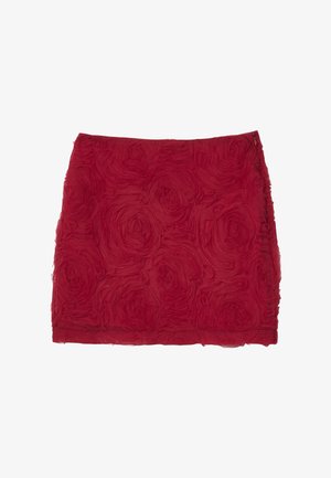 Mini-jupe rouge avec des motifs de roses texturés et une fermeture éclair sur le côté, présentée à plat sur un fond blanc.