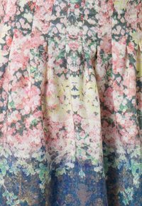 Tejido con un patrón floral que presenta tonos de rosa, verde y amarillo, con pliegues. Textura suave con un diseño ligero y fluido.