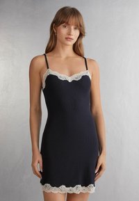 Abito camicetta blu navy con bordo in pizzo crema scalloppato sul collo e sull'orlo, caratterizzato da spalline sottili e regolabili e una vestibilità aderente.