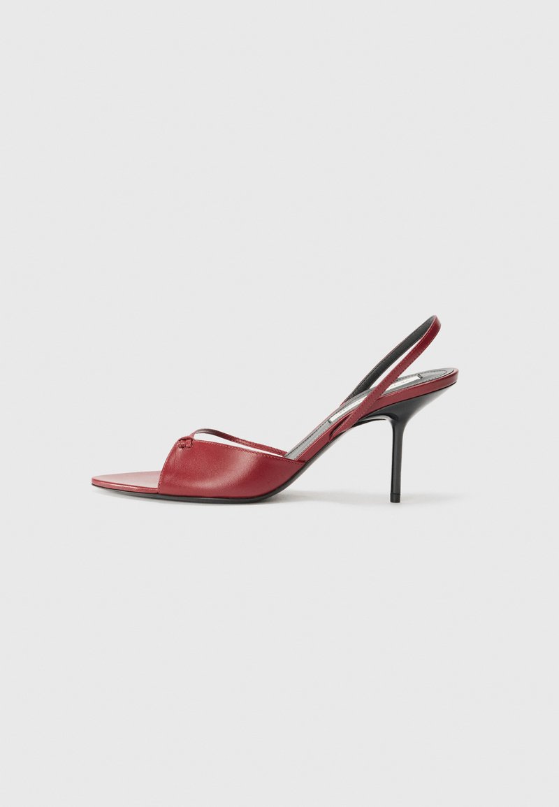 Sandalia de tacón en piel roja, con diseño de punta abierta, tira delgada sobre el pie y tacón stiletto estrecho.