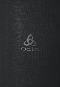 Čierna atletická tkanina s jemnou textúrou a leskom. Obsahuje logo Odlo vo svetlejšej šedej farbe, umiestnené na boku.