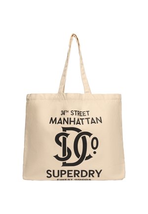Beżowa torba typu tote z długimi uchwytami, na froncie czarny napis "34th Street Manhattan", stylizowane "DC Co" oraz logo "Superdry Finest Goods".