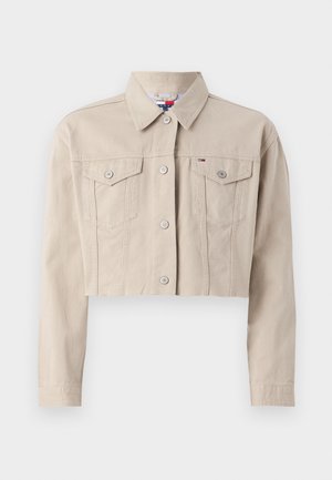 Jaqueta de ganga bege cortada com colarinho, fecho de botão, dois bolsos no peito e detalhes em prateado. Textura suave e ajuste feito à medida.