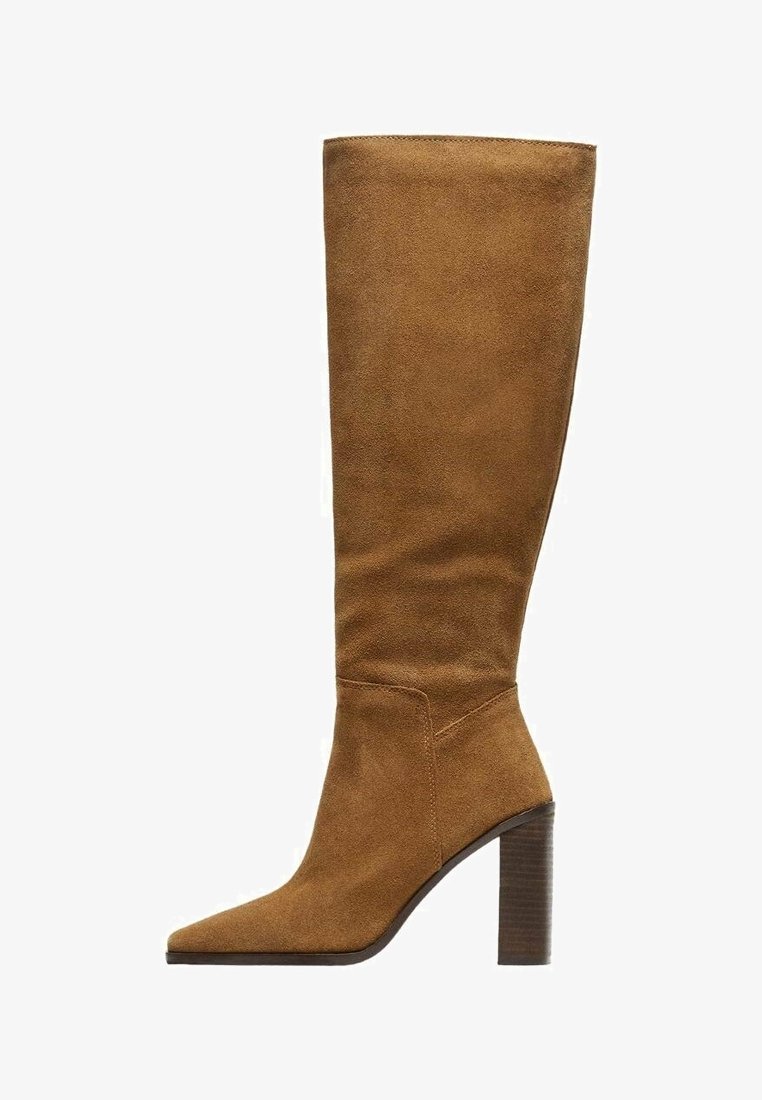 Botte en suède beige hautes jusqu'au genou, avec un bout pointu et une surface texturée. Talon épais marron, présentant une silhouette épurée et un detailing minimal.