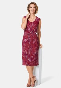 Maxikleid in Rot mit Blumenmuster, ärmelloses Design, tailliert, fließender Stoff, kombiniert mit pinken Knöchelriemchen-High Heels.