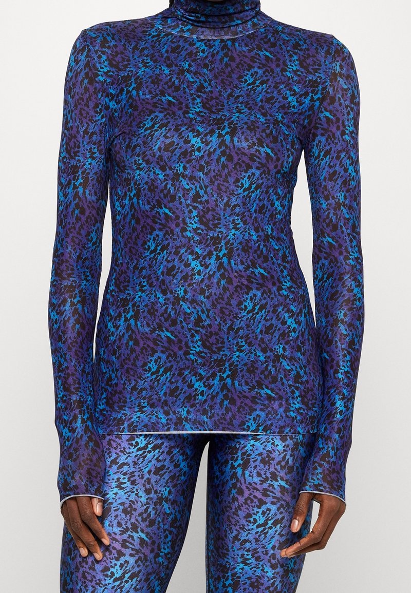 Pitkähihainen paita korkealla kauluksella, jossa on läpinäkyvä, joustava kangas ja elinvoimainen sinivioletti eläinkuos.