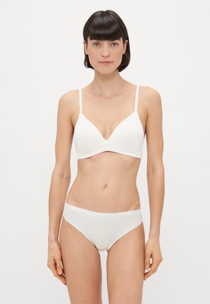 Biały bezszwowy biustonosz z dekoltem w kształcie litery V i cienkimi, regulowanymi ramiączkami, w zestawie z pasującymi majtkami o wysokim stanie z gładkiego, elastycznego materiału.