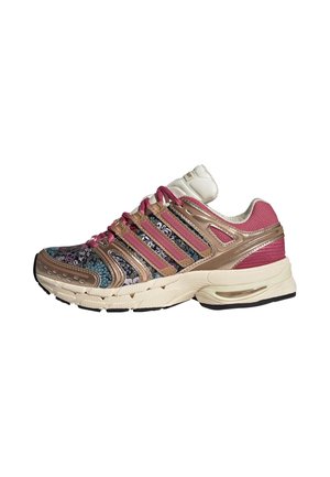 Niedriger Sportschuh aus floral gemustertem Stoff, mit goldenen und pinken Streifen, pinken Schnürsenkeln und cremefarbener Sohle mit schwarzem Profil.