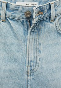 Světle modré džíny z denimu s klasickým pětipocket designem. Obsahují kovový knoflík, zipový uzávěr a oranžové švy.