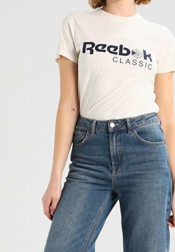Bílá bavlněná trička s námořnickým logem "Reebok CLASSIC", spojená s džíny modré barvy s vysokým pasem. Jednoduchý design, hladká textura, volný střih.