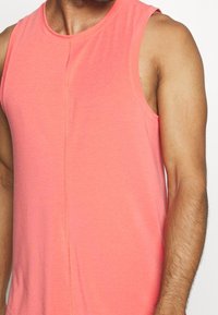 Korala bezrękawnik z miękkiego materiału, z okrągłym dekoltem, subtelnymi detalami szwów i luźnym krojem.