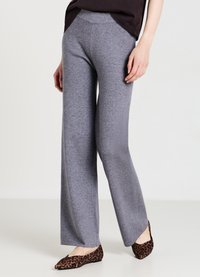 Graue ausgestellte Hosen aus weichem Stoff mit einem weiten Bein-Design. Getragen mit flachen Schuhen im Tierdruck, die eine glatte, strukturierte Oberfläche präsentieren.