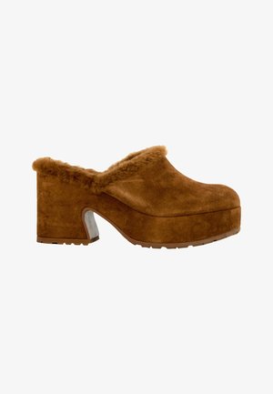 Sabot à plateforme en daim marron avec talon bloc et doublure duveteuse visible autour du col, vu de côté sur fond blanc.
