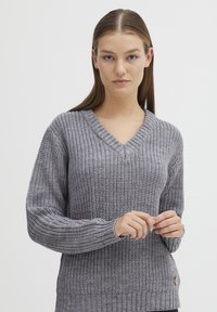 Grauer gestrickter Pullover mit V-Ausschnitt, gerippten Bündchen und unterem Saum. Verfügt über ein strukturiertes Muster und ein kleines Logo-Detail an der Seite.