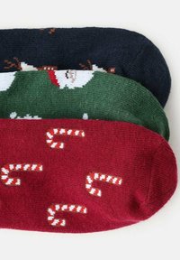 Balenie troch párov ponožiek: námornícka modrá so sobom, zelená s Mikulášom a červená so vzorom cukrovej trstiny. Mäkký pletený materiál s kontrastnými farbami.