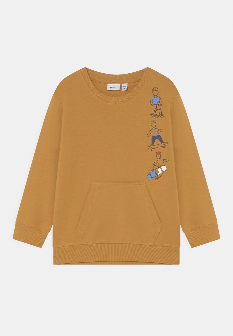 Sweat-shirt moutarde à manches longues avec poche avant et illustrations de trois enfants faisant du skateboard verticalement sur le côté gauche de la poitrine.