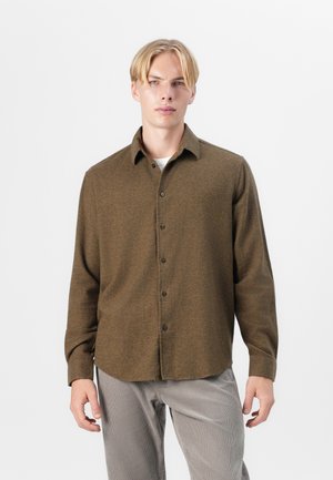Brown button-up shirt made of textured fabric, featuring a collar and long sleeves, paired with light striped pants.