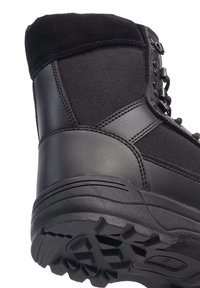 Black outdoor boot with a textured fabric upper, rubber sole, and reinforced heel. Features metal eyelets and a soft, padded collar.