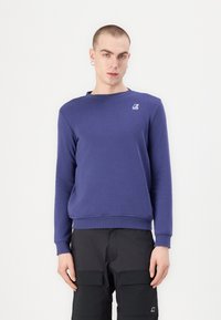 Paarse katoenen sweatshirt met een ronde hals en lange mouwen. Heeft een klein logo op de borst en ribgebreide manchetten en onderzoom.