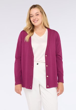 Cardigan violet vibrant en maille douce, présentant une coupe décontractée, des bords côtes et des boutons dorés sur le devant.