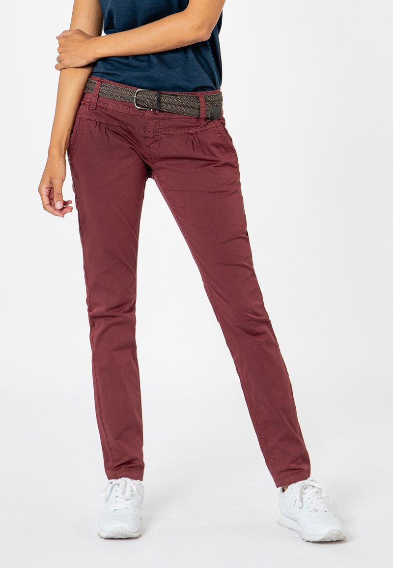 Burgundy slim-fit pants with a textured woven belt. Cotton material, side pockets, and a smooth finish. Paired with white sneakers.