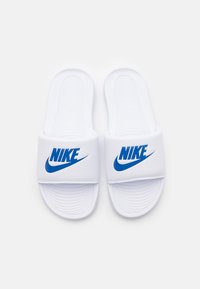 Hvide slidesandaler lavet af syntetisk materiale med et blåt Nike-logo på remmen og en struktureret fodseng for bedre greb.