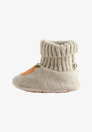 Scarpina per neonati beige lavorata a maglia con polsino a costine e dettagli ricamati arancioni e verdi sulla suola morbida.