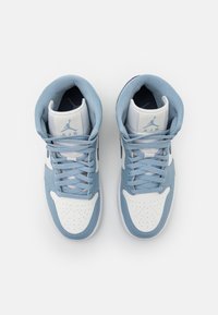 Pár modro-bílých vysokých tenisek s uvázanými tkaničkami, pohled shora na čistém bílém pozadí.