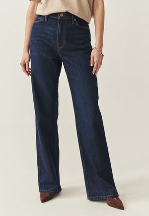 Ciemnoniebieskie dżinsy o szerokich nogawkach z pomarańczowym przeszyciem, wysoki stan, przednie kieszenie i zapięcie na guzik w pasie.