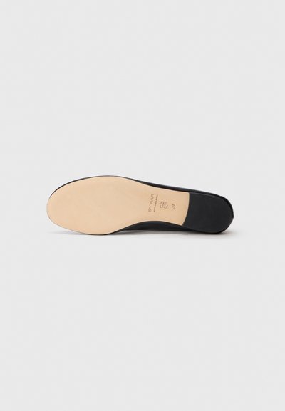 Suola di scarpa in pelle nera con una finitura liscia, caratterizzata da un tacco in gomma beige e dettagli del marchio embossati.