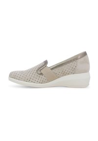 Scarpa beige slip-on con tomaia perforata, dettaglio elasticizzato e accenti metallici. La suola a cuneo leggera aggiunge altezza e comfort.