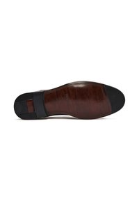 Semelle en cuir marron légèrement texturée, avec un embout en caoutchouc noir. Coutures détaillées tout autour.