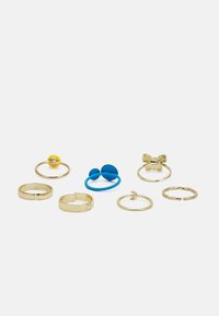 Conjunto de oito anéis, incluindo faixas de metal dourado, um anel de silicone azul e um detalhe em forma de borboleta dourada. Apresenta várias formas e texturas.