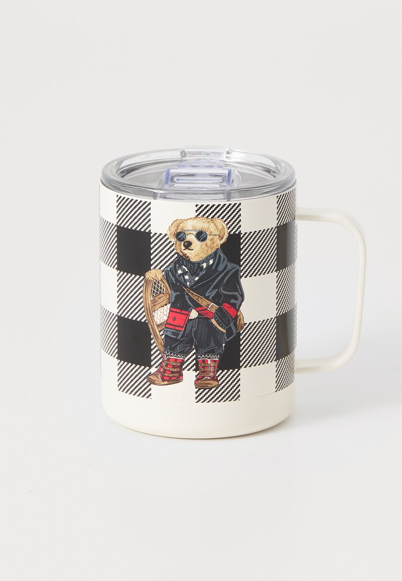 Caneca branca com padrão quadriculado preto e branco, apresentando um urso de pelúcia com óculos de sol, um casaco preto, botas vermelhas e a segurar uma cadeira.