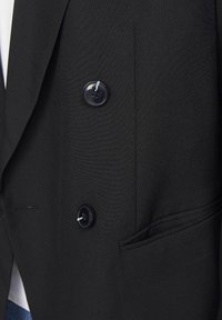 Zwarte blazer met een dubbelzijdig ontwerp, een gladde textuur, twee grote knopen en een zijzak met een subtiele gestikte detail.