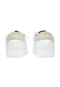 Sneakers bianchi con pelle liscia e tallone in suede texturizzato. Presentano un accento nero sul tab del tallone e una tomaia perforata per la traspirabilità.
