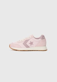 Lys rosa joggesko med en teksturert semsket tåhette og side, med en mørkere rosa stjernelogo og kremfargede lisser. Brun gummisåle.