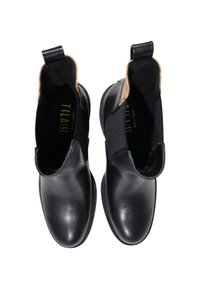 Botas de tobillo de cuero negro con paneles elásticos a los lados y asas en la parte superior. Textura suave con punta redondeada y suela plana.