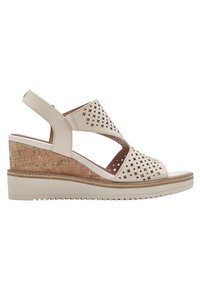 Sandale compensée beige avec motifs découpés en étoile et cercle, bout ouvert, bride arrière et talon à texture liège.