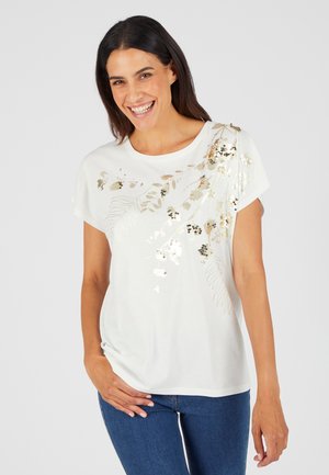 T-shirt blanc à manches courtes avec broderie en sequins floraux dans des tons dorés et argentés sur l'épaule, coupe décontractée, texture lisse.