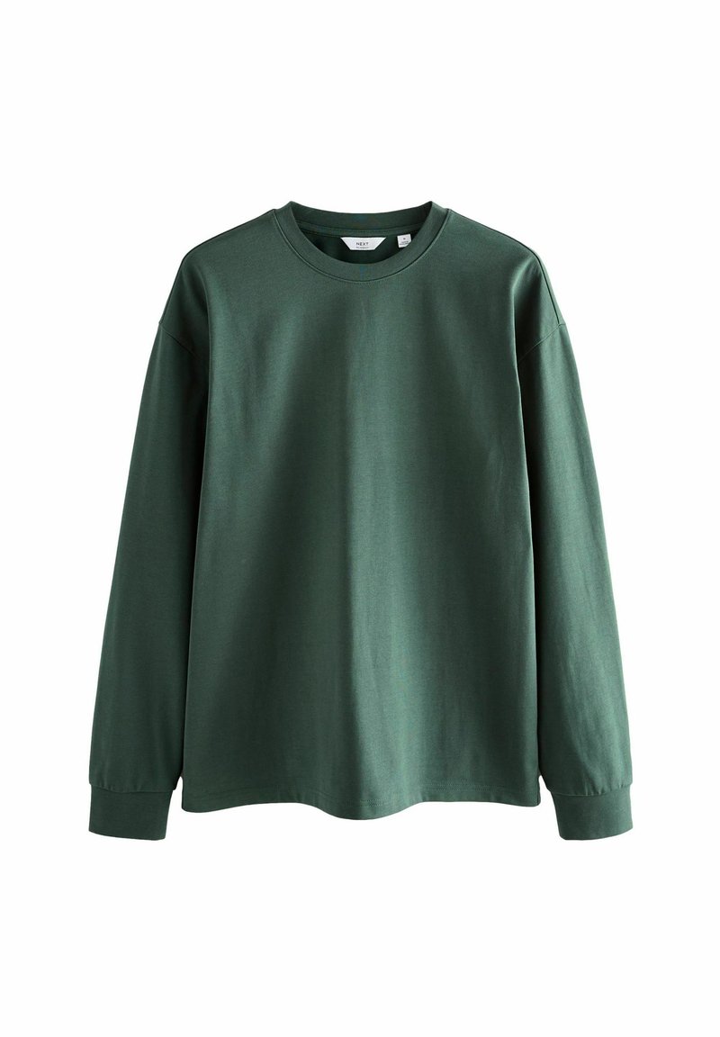 Langärmliges T-Shirt aus tiefgrünem Baumwollstoff, Rundhalsausschnitt, lockere Passform, überschnittene Schultern und gerippte Bündchen mit glatter Textur.