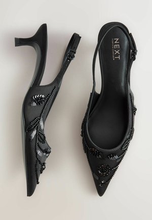 Mustad seljaosas kõrgendatud kontsad, terava varbaga, kaunistatud helme ja sequin lillemustritega, peene sünteetilise materjaliga ja saleda kannaga.