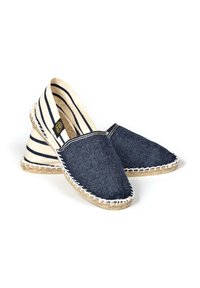 Espadrilles bleu marine avec un extérieur en denim, doublure en coton rayé et semelles en jute. Présente des coutures blanches le long des bords.