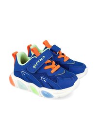 Zapatillas infantiles azules con cordones naranjas, interior verde, suela blanca con acentos translúcidos coloridos y cierre de tiras de Velcro.