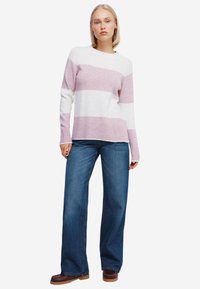 Maglione a righe rosa e bianco, realizzato in materiale morbido, con maniche lunghe e scollatura rotonda, abbinato a jeans a gamba larga blu.
