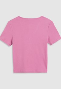 Haut court à manches courtes côtelé rose avec un col rond et un ourlet droit. Présente un tissu texturé avec des lignes verticales visibles sur toute la surface.