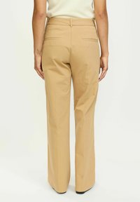 Kaki široke hlače s glatkom teksturom, s prilagođenim strukom, dva stražnja džepa i urednim rubovima.