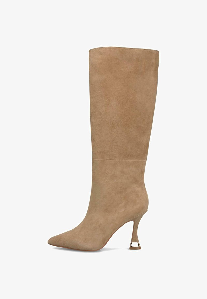Botte en suède beige montée jusqu'au genou avec un bout pointu et un talon aiguille, présentant un design découpé distinctif au niveau du talon. Texture lisse.